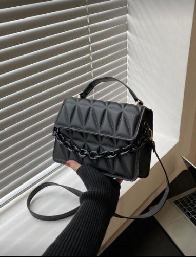 Cartera negra con cadena decorativa